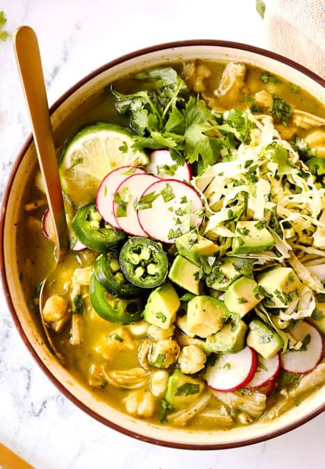 top up close view of showing how to top pozole verde de pollo with radishes, cilantro, avocados and radishes