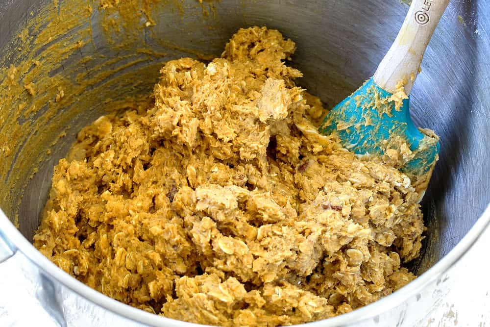 showing how to make pumpkin oatmeal cookies by mixing dry ingredients into wet ingredients