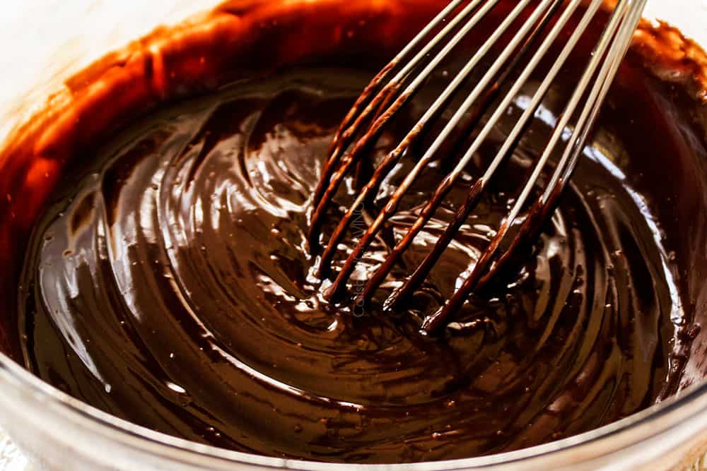 showing how to make Boston Cream Pie by whisking hot cream and chopped chocolate together until smooth to make chocolate glaze