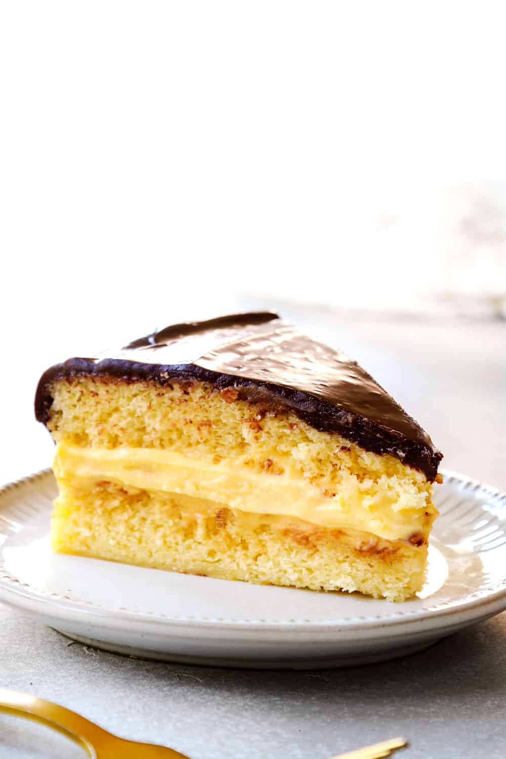 up close of a slice of Boston Cream Pie showing how thick the pastry cream is