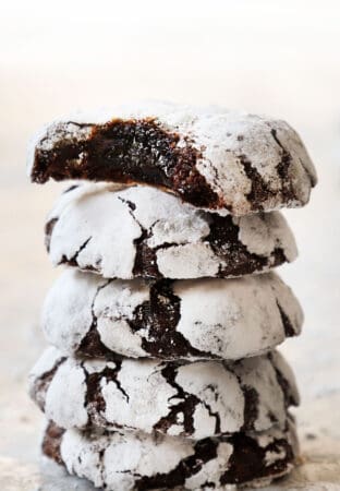 chocolate crinkle cookies stacked showing how thick they are