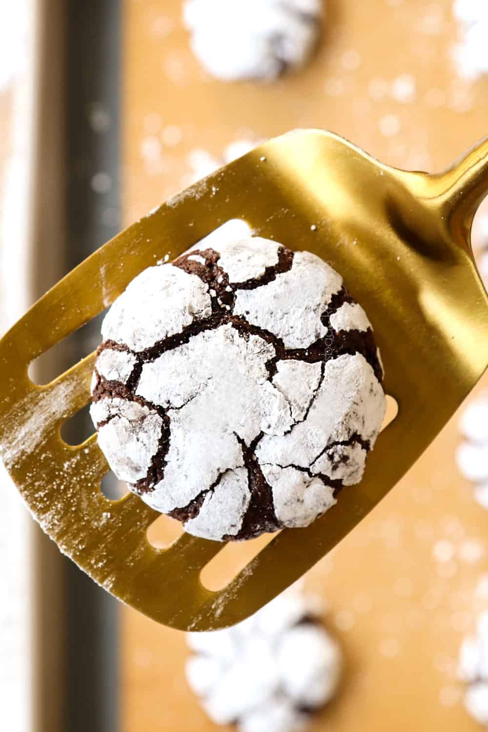 up close of a chocolate crinkle cookie on the spatula