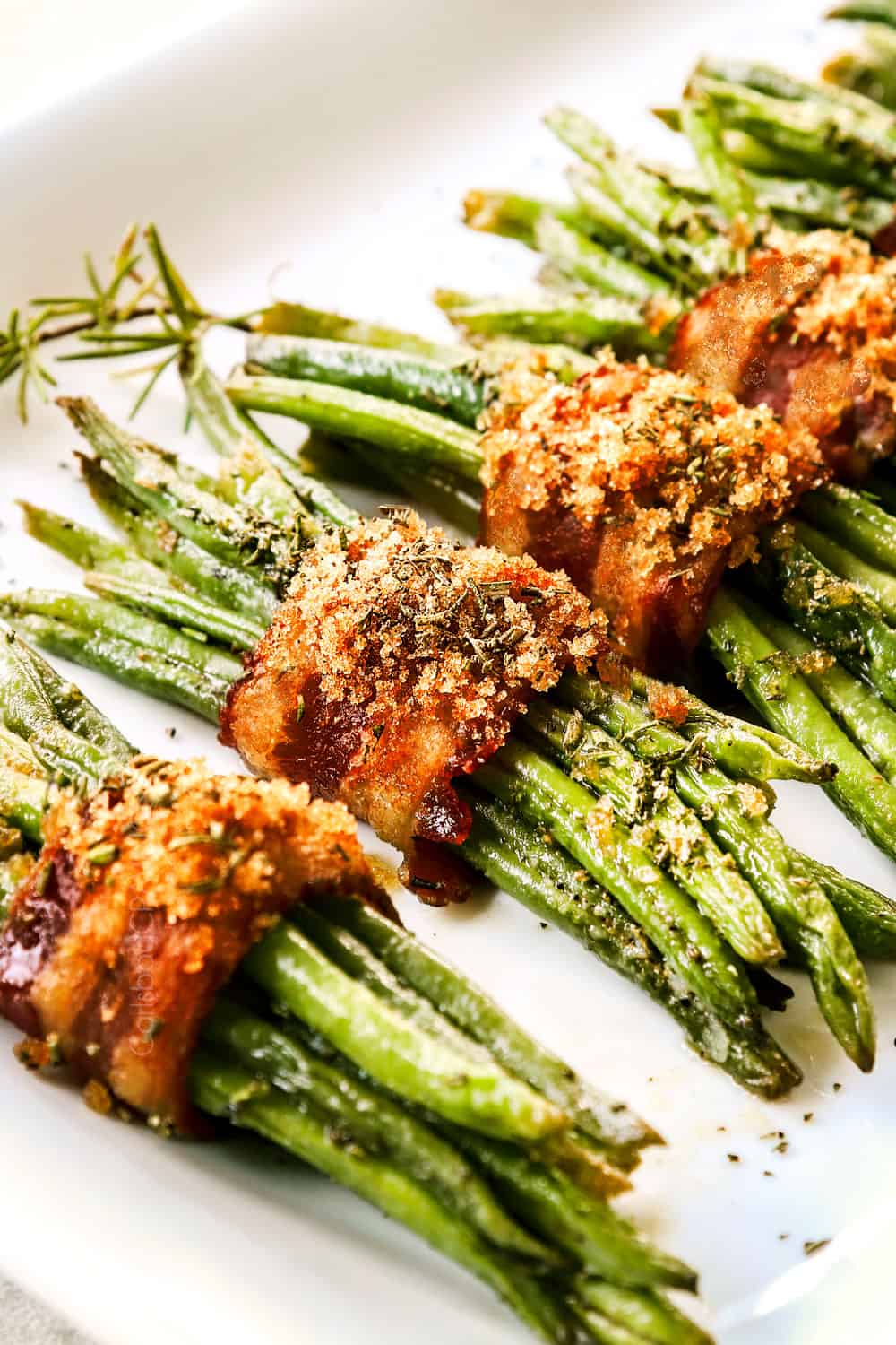 up close of bacon wrapped green bean bundles with crispy bacon