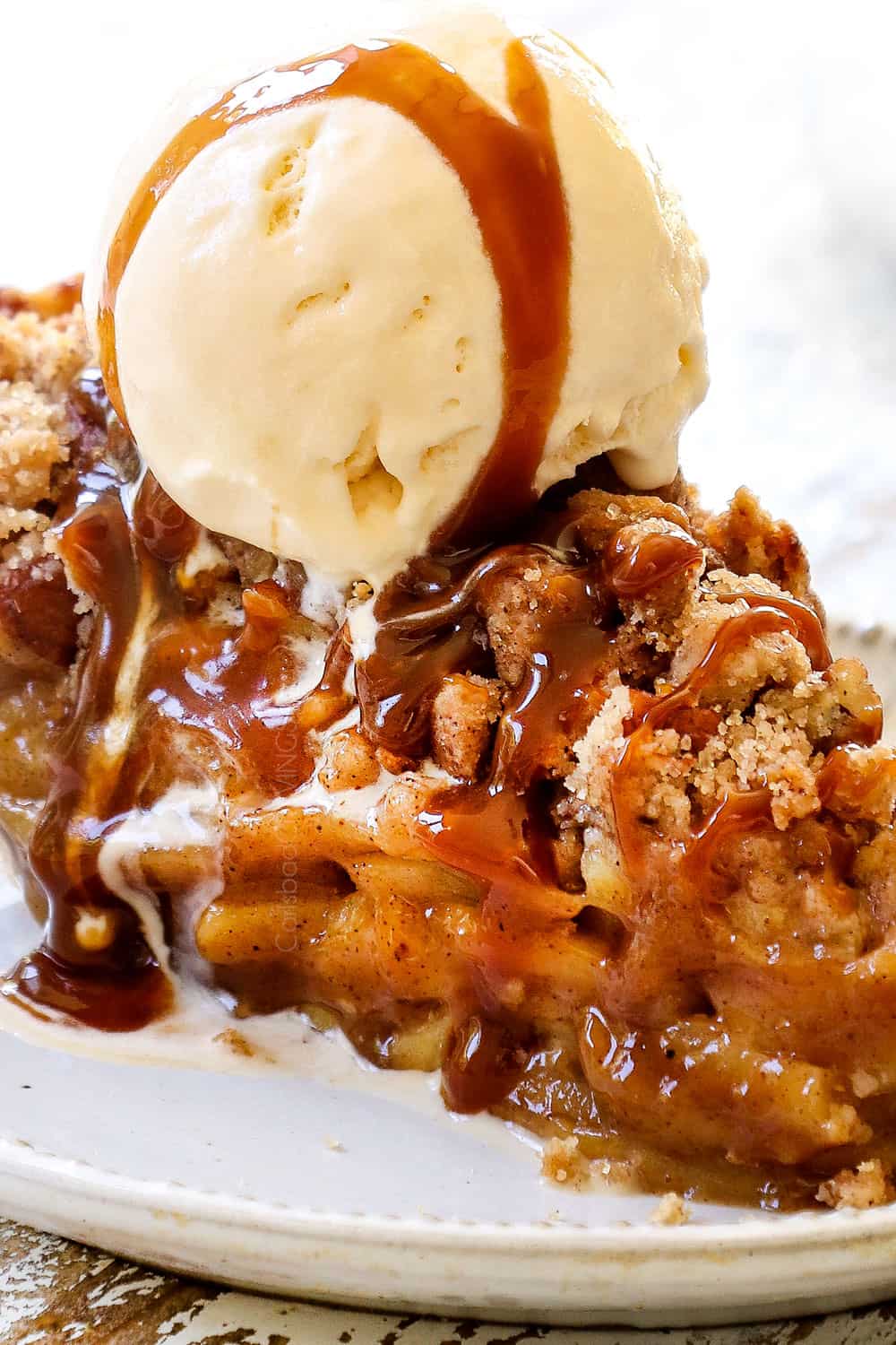 up close of a slice of Dutch Apple Pie (Apple Crumble Pie) with crumble topping and ice cream
