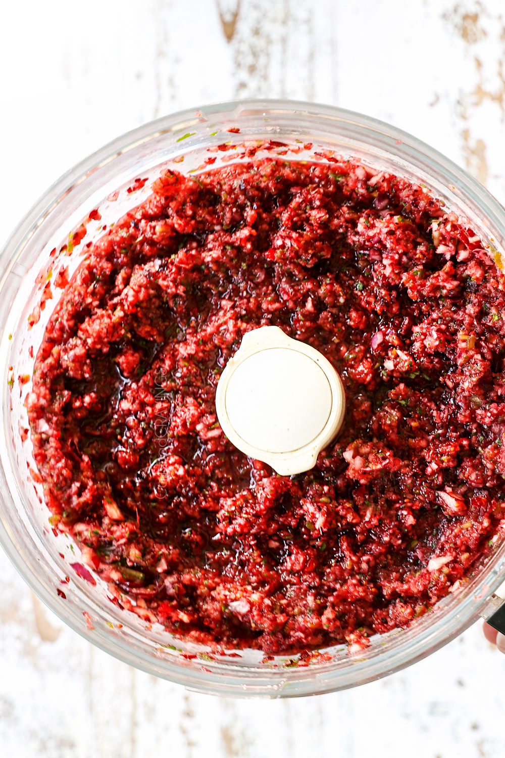 showing how to make cranberry salsa by blending all of the ingredients in a food processor