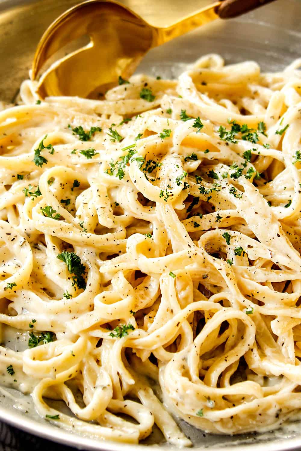 up close of best fettuccine Alfredo in a skillet garnished by parsley