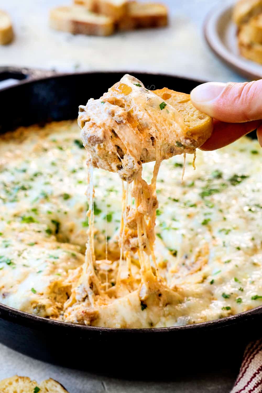 a cheese shot of scooping up Philly cheesesteak dip recipe showing how cheesy it is
