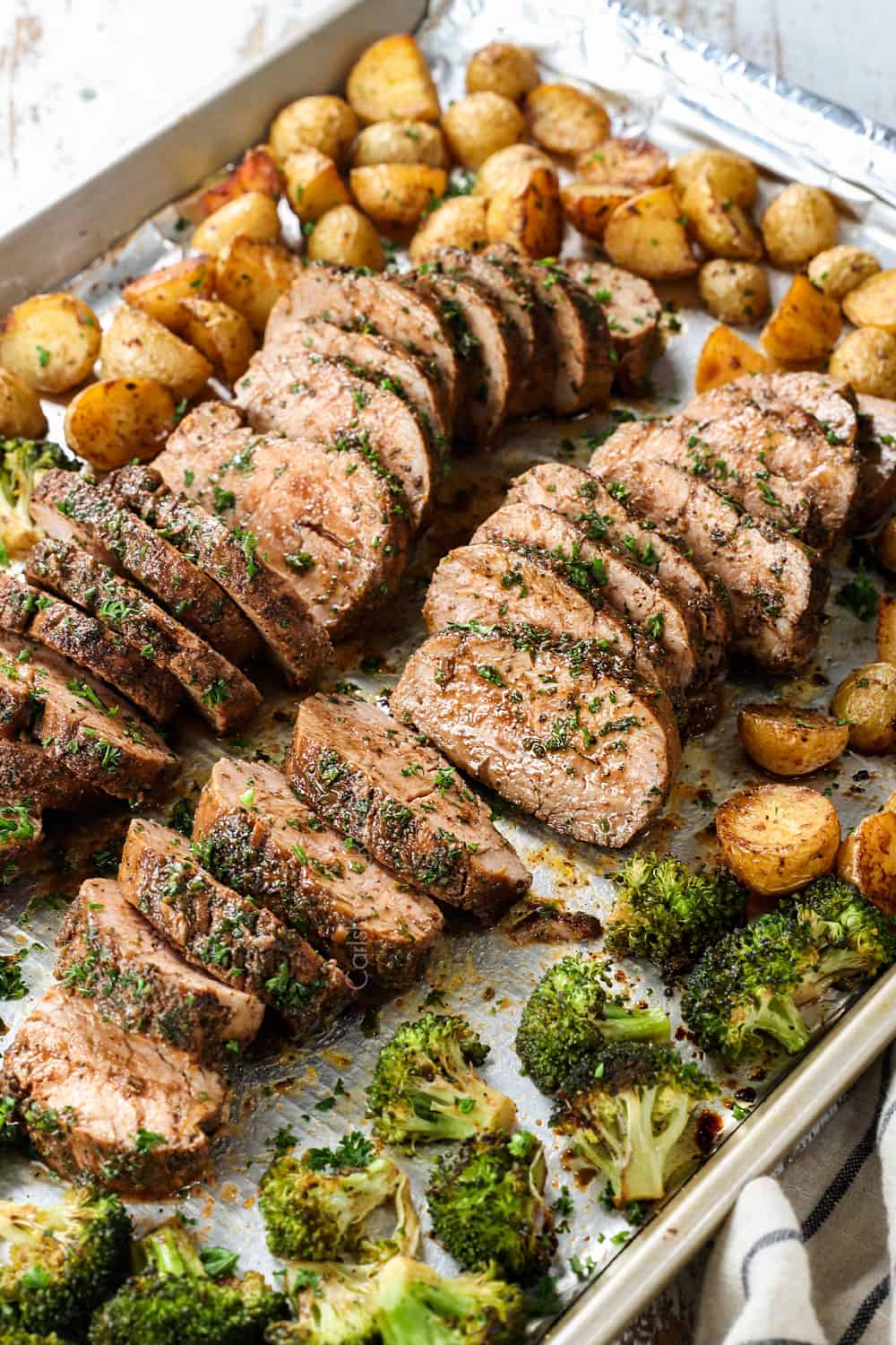 balsamic pork tenderloin roasted in the oven sliced on a baking sheet garnished by parsley