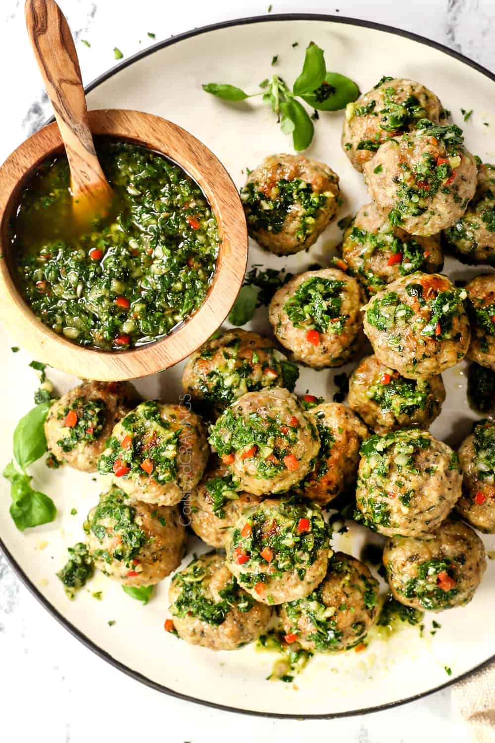showing how to serve best chimichurri sauce recipe by drizzling it on meatballs