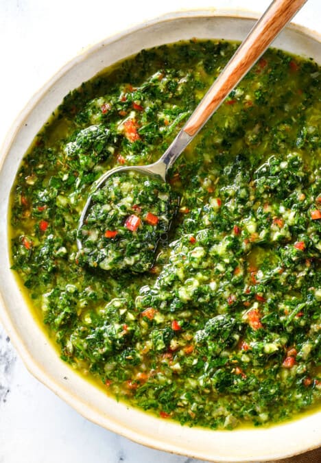 top view of the best chimichurri sauce recipe with parsley, oregano, red chili flakes, garlic and olive oil