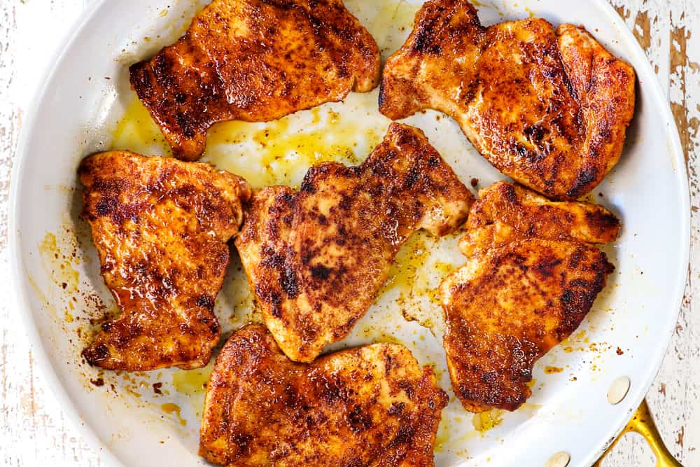 showing how to make honey lime chicken by searing the chicken thighs in a nonstick skillet