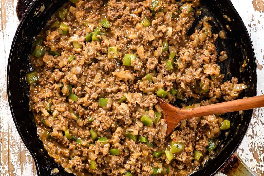 showing how to make Philly Cheesesteak Sloppy Joes by simmering until thick and saucy