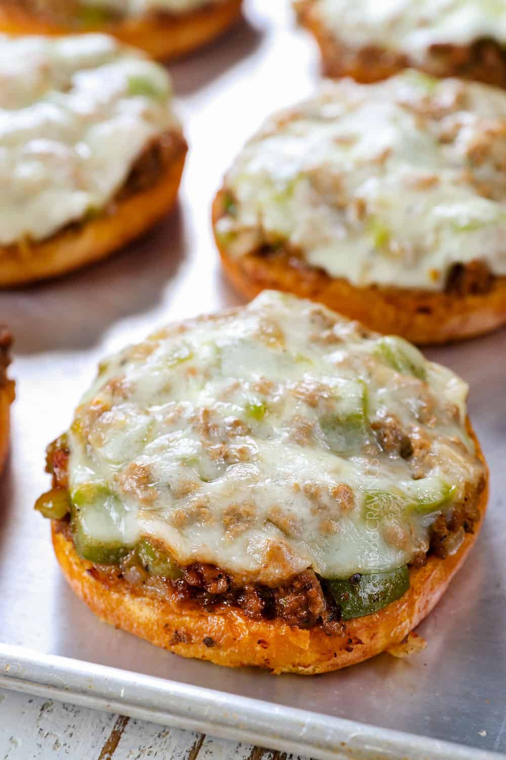 showing how to make Philly Cheesesteak Sloppy Joes by melting provolone over Sloppy Joe filling
