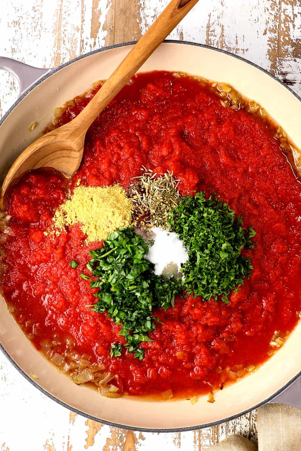 top view of tomato sauce showing the ingredients of crushed tomatoes, basil, parsley, oregano, thyme and sugar
