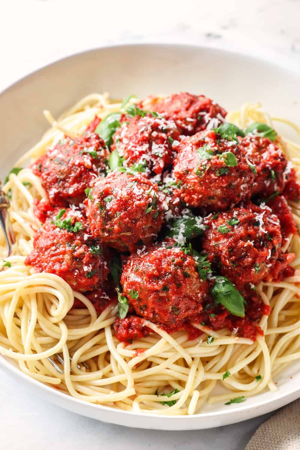 showing how to serve tomato sauce by adding to spaghetti and meatballs