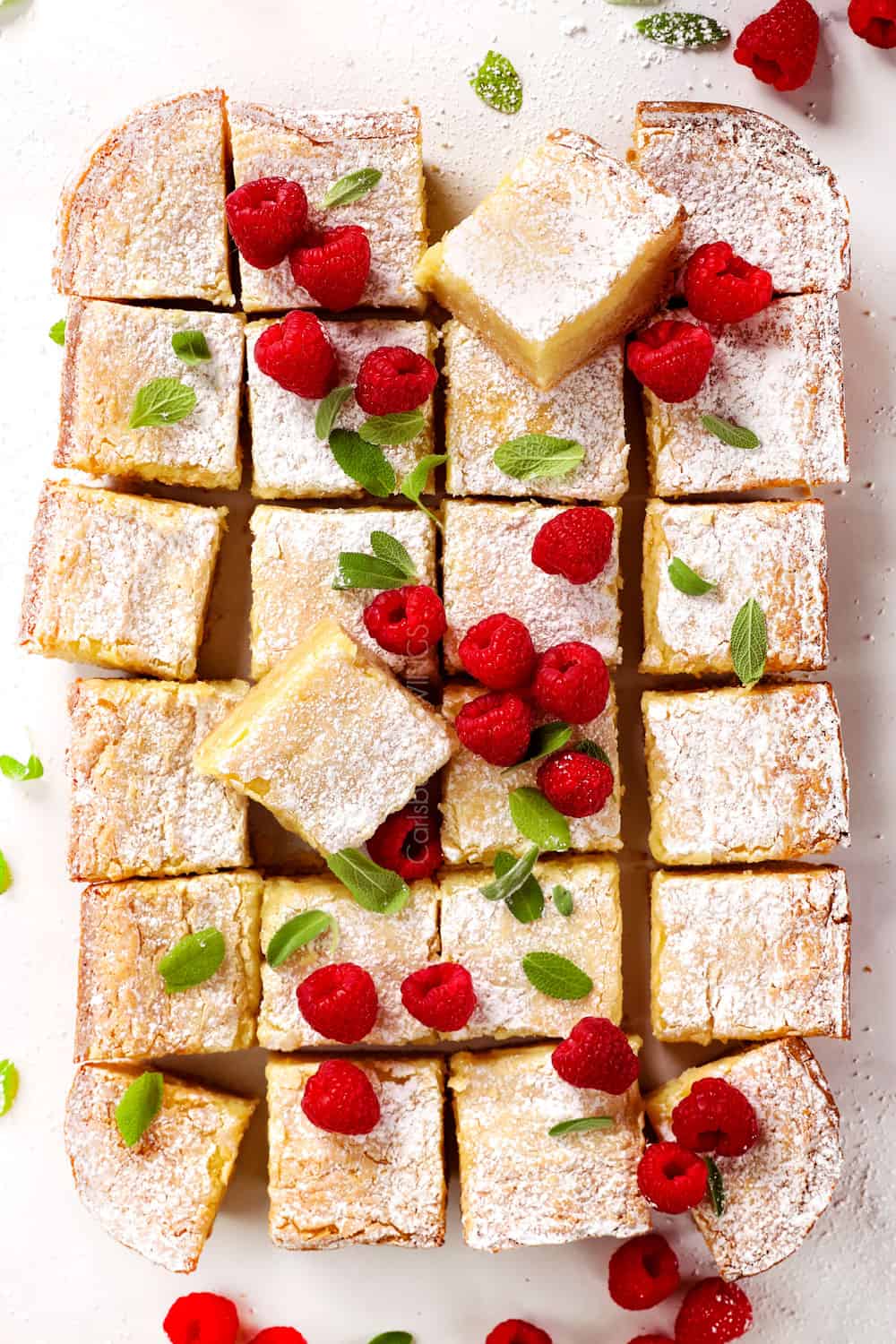 top view of St. Louis Gooey Butter cake sliced in squares garnished with raspberries