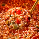 a ladle of stuffed pepper soup recipe with red and green bell peppers, Italian sausage and rice