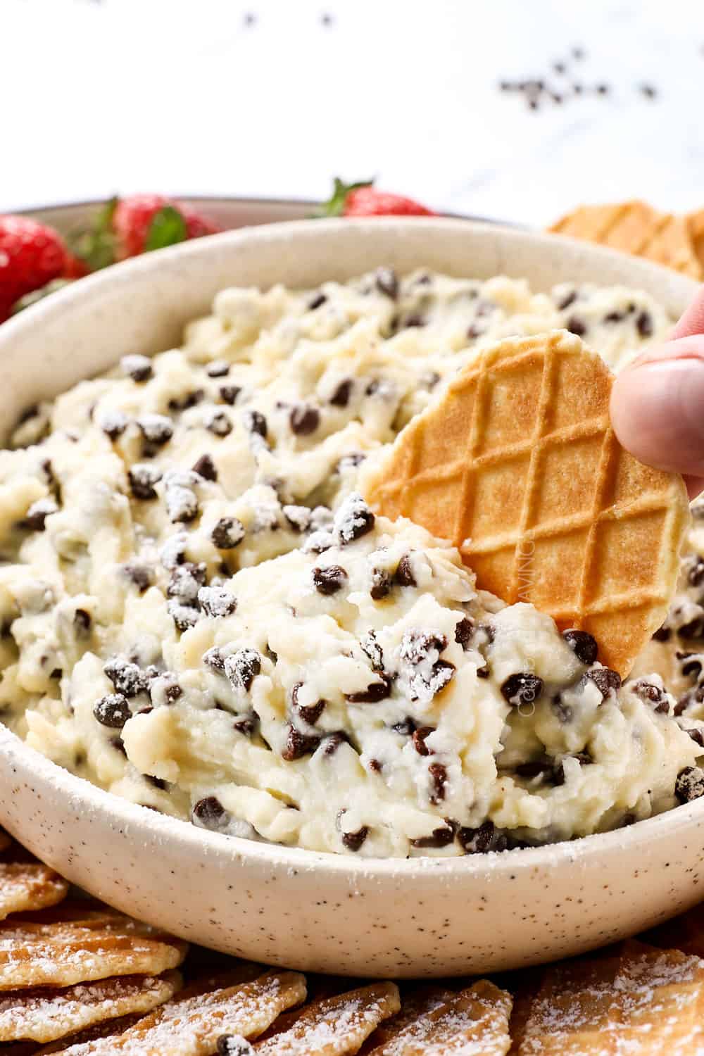 up close of cannoli dip on a waffle cookie dipper showing what to serve it with