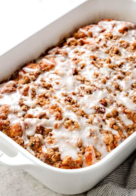 side view of cinnamon roll french toast casserole with icing and pecan topping