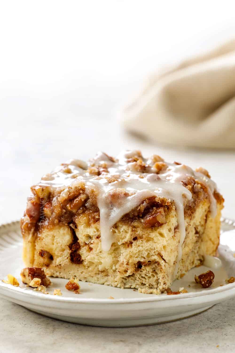 a slice of cinnamon roll French toast drizzled with icing showing how fluffy it is
