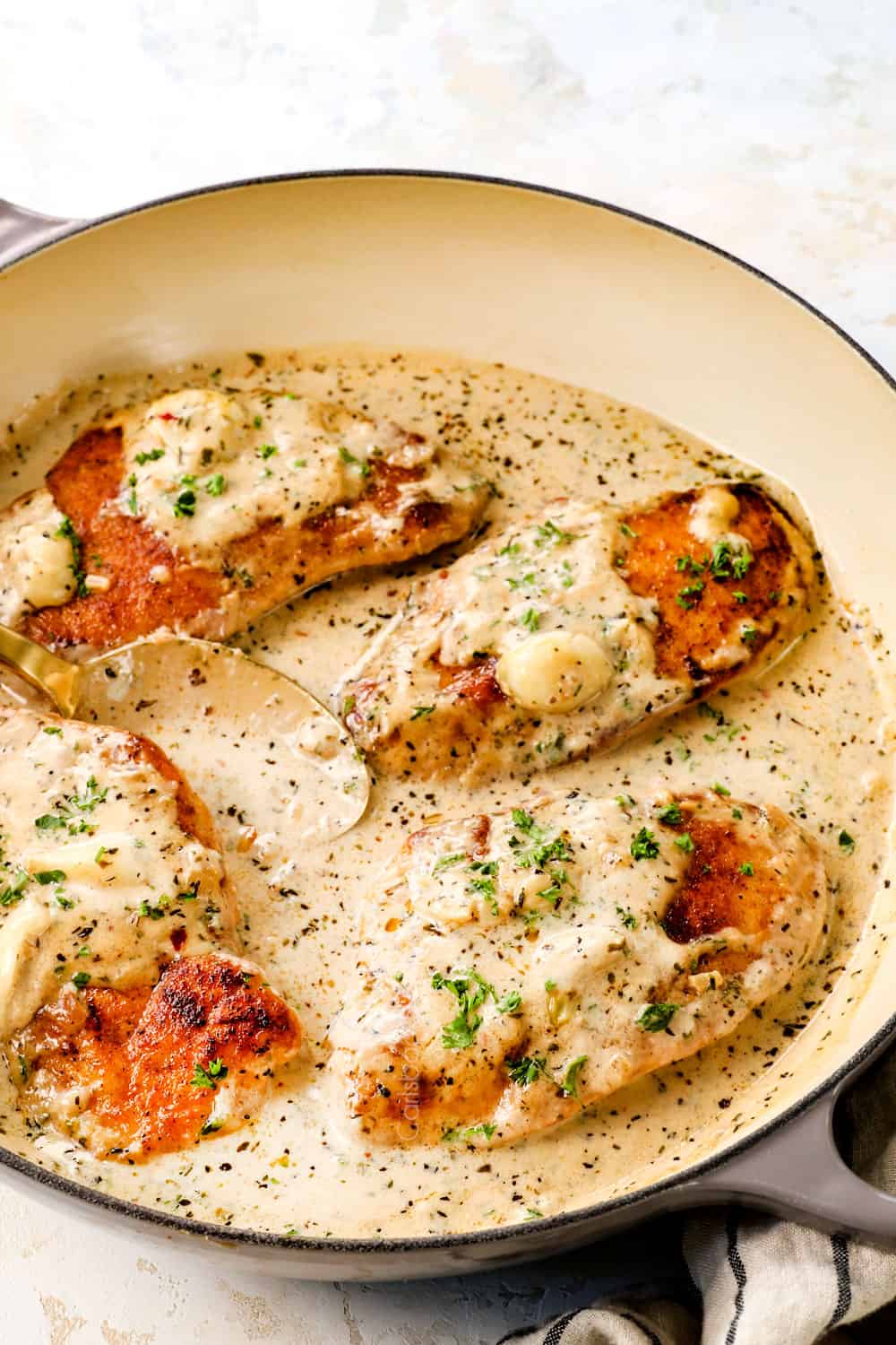 creamy garlic chicken in a pan showing how creamy the Parmesan sauce is