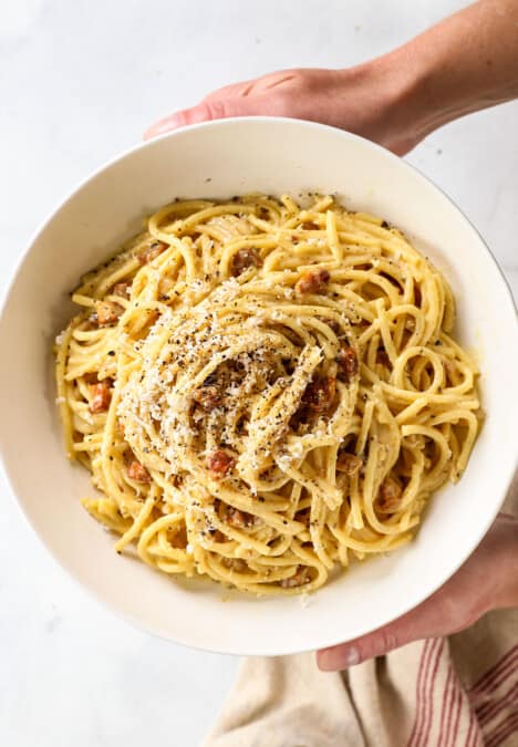 top view of spaghetti carbonara garnished with pecorino Romano and pepper
