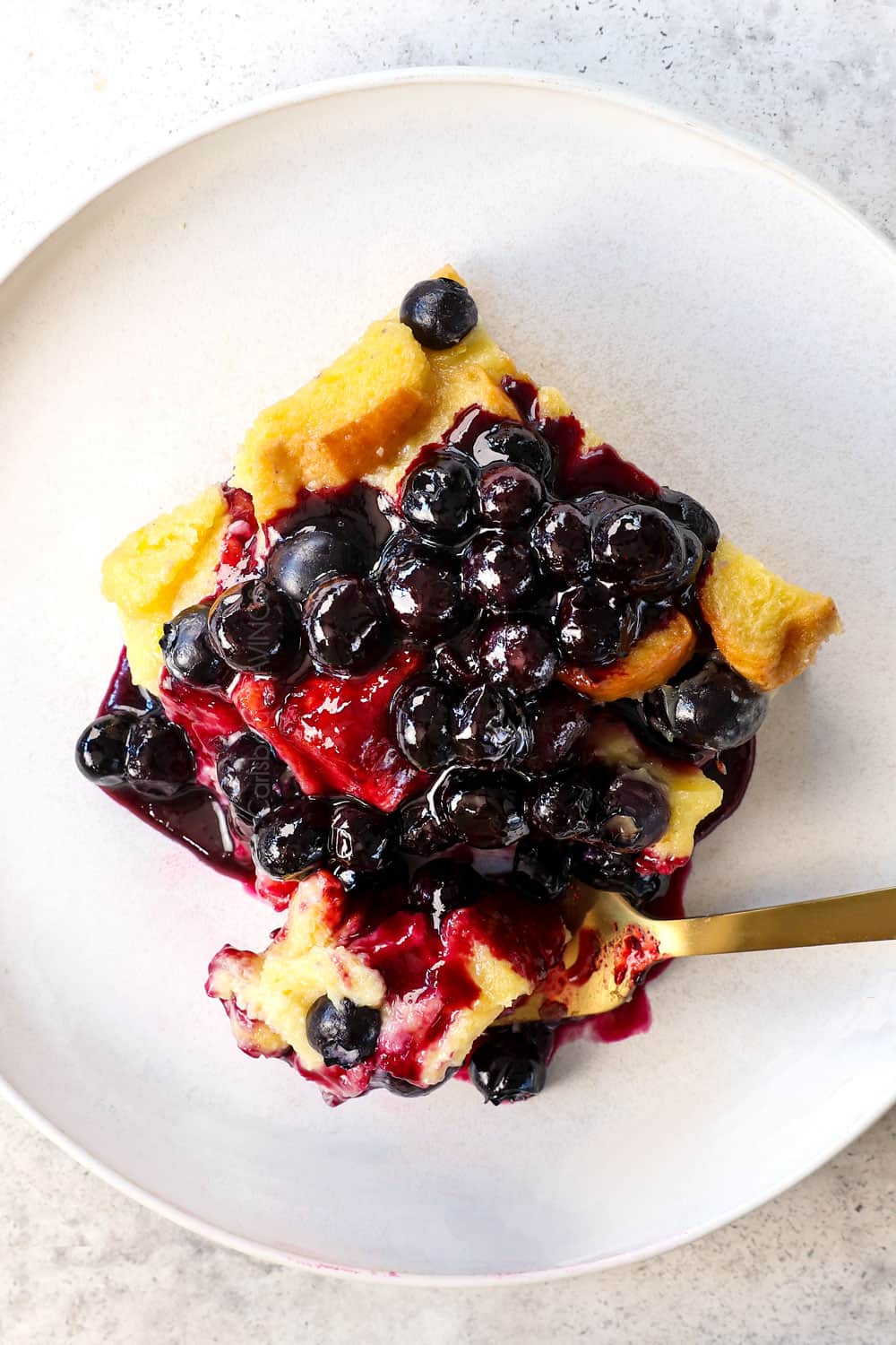 top view of a slice of Blueberry French Toast Casserole recipe with blueberry sauce