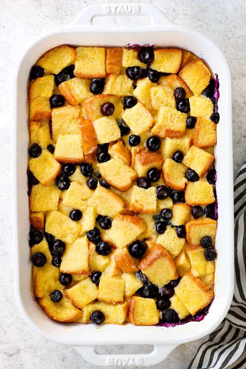 showing how to make blueberry French toast casserole by baking until golden