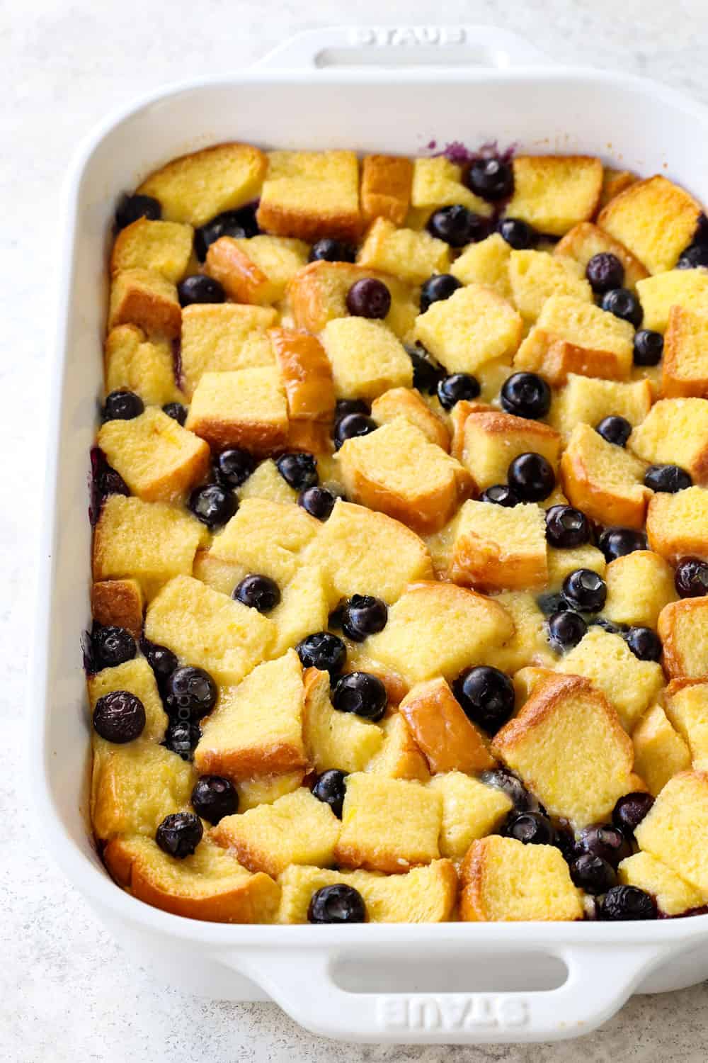 Blueberry French Toast Casserole in a 9x13 baking dish with fresh blueberries