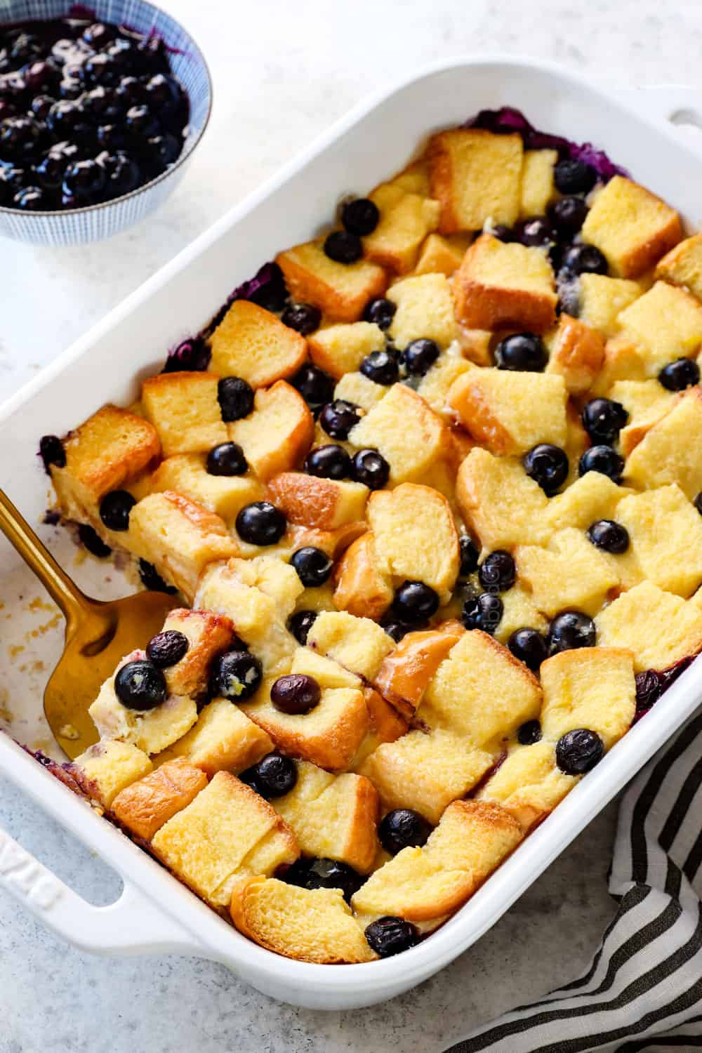 easy Blueberry French Toast Casserole with a spatula ready to serve
