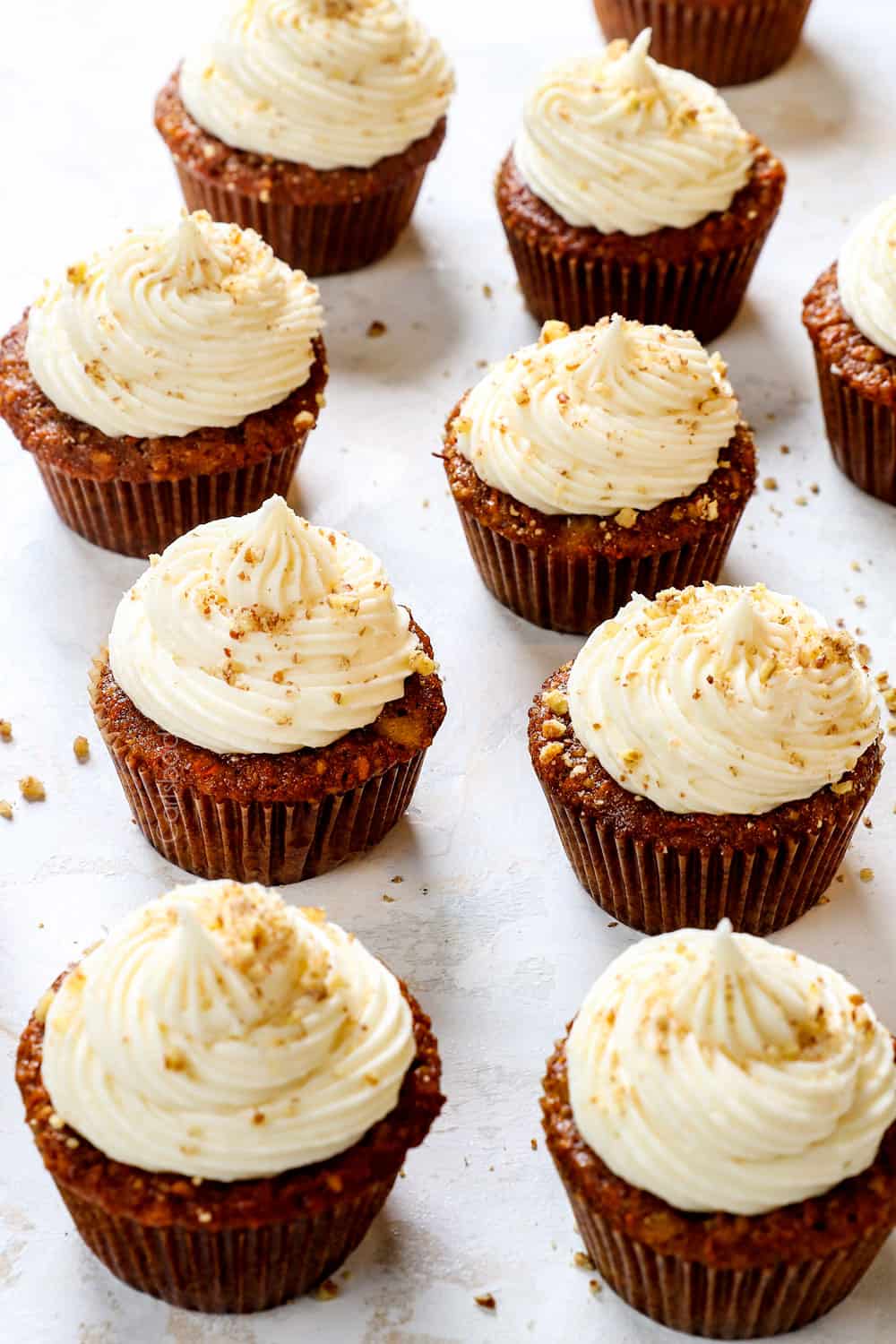 a row of carrot cake cupcakes with pecans