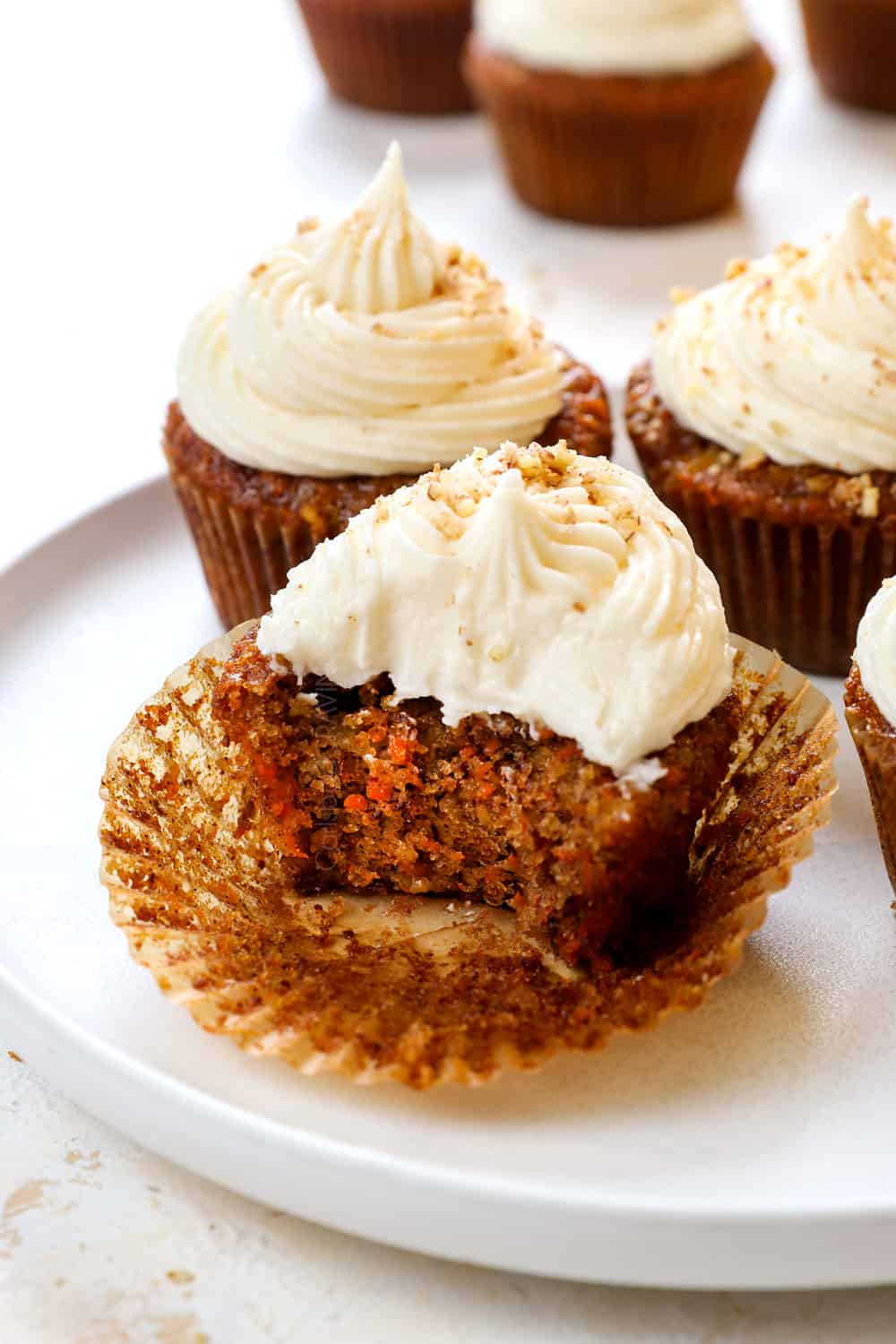 up close of carrot cake cupcake on a white serving plate