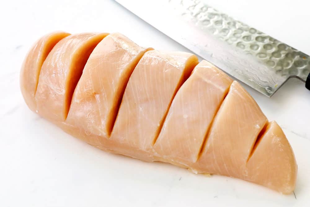 showing how to make Hasselback Chicken by slicing slits across the chicken breast without cutting through