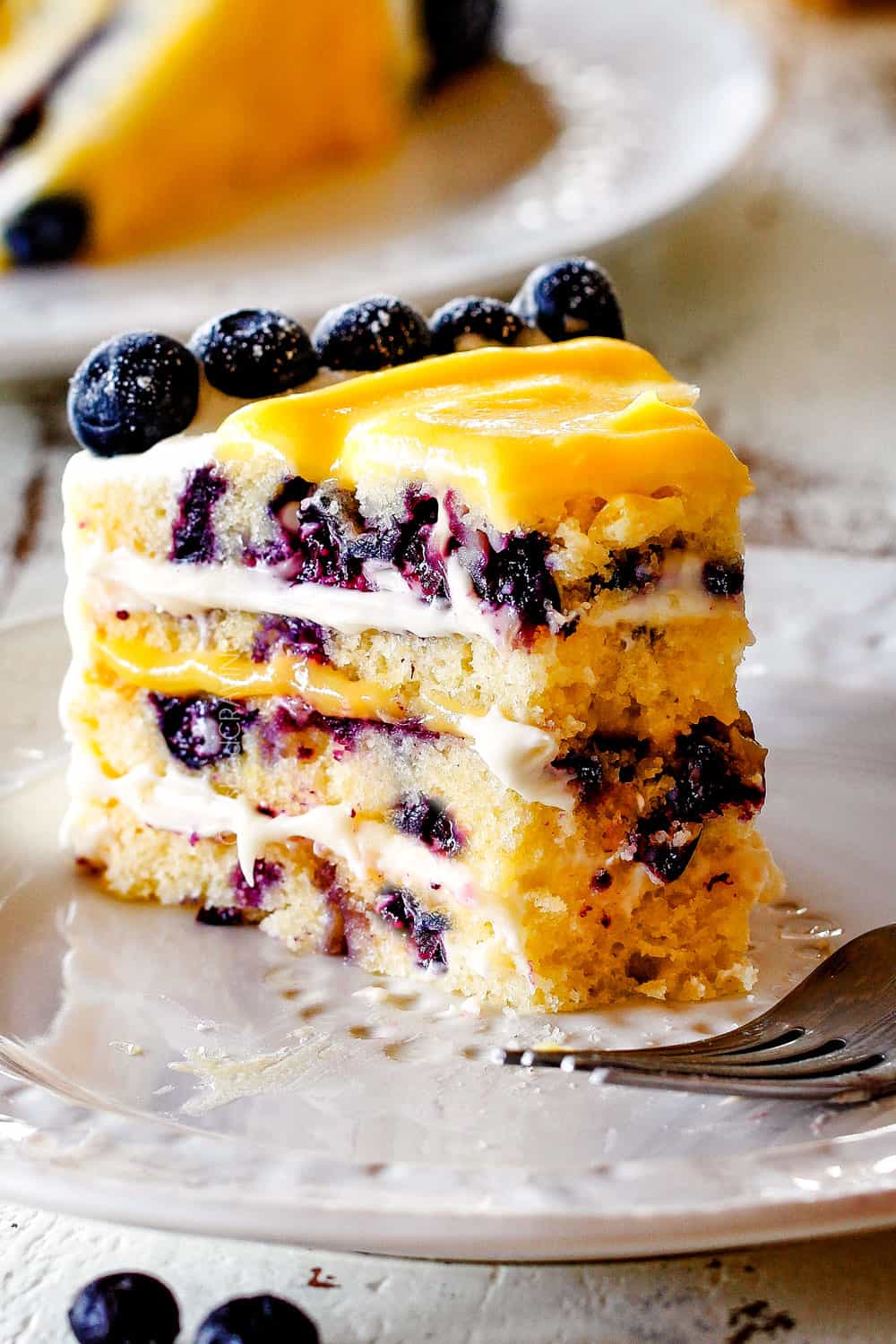 lemon curd for cake in between layers of blueberry lemon cake