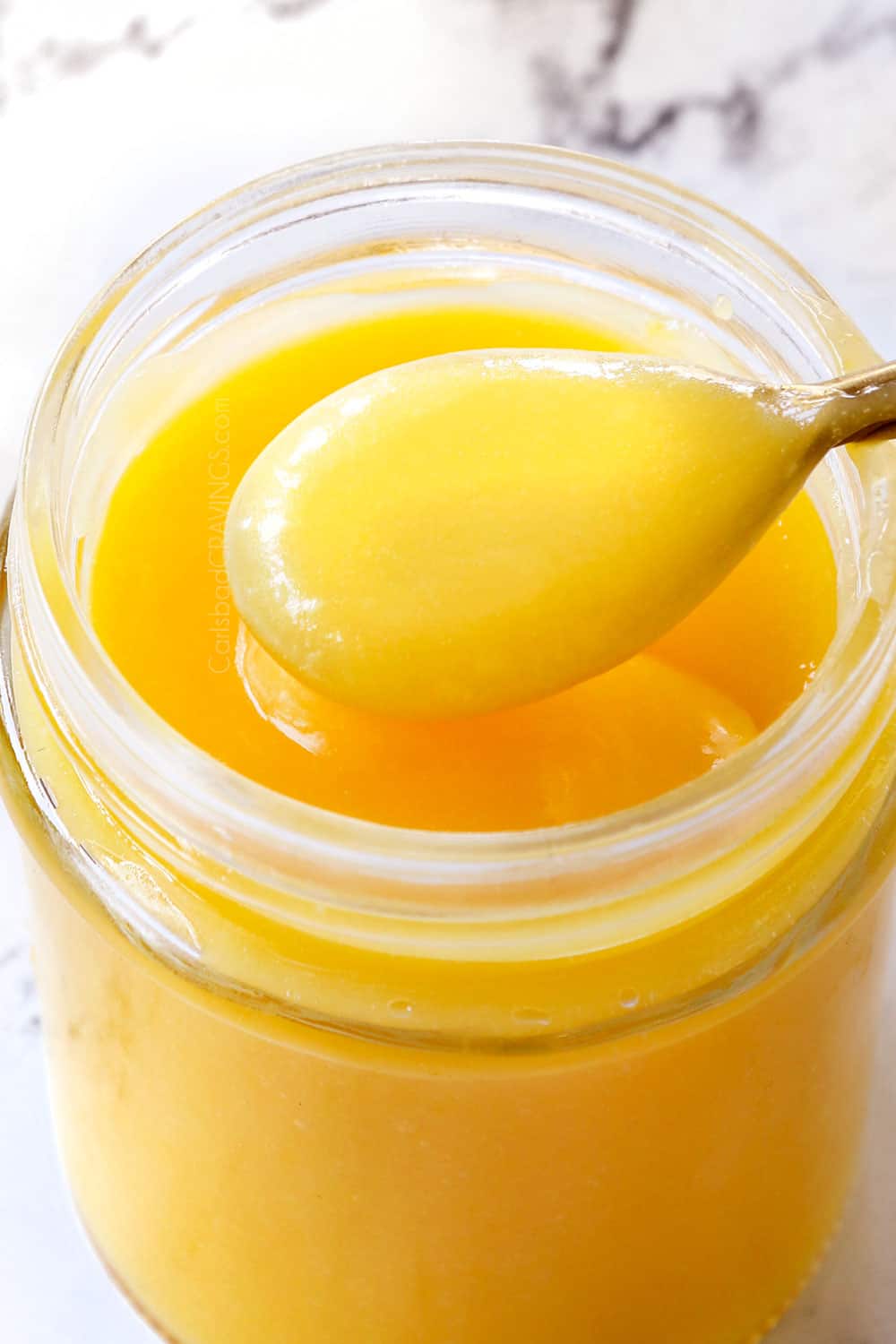up close of lemon curd in a jar showing how creamy it is