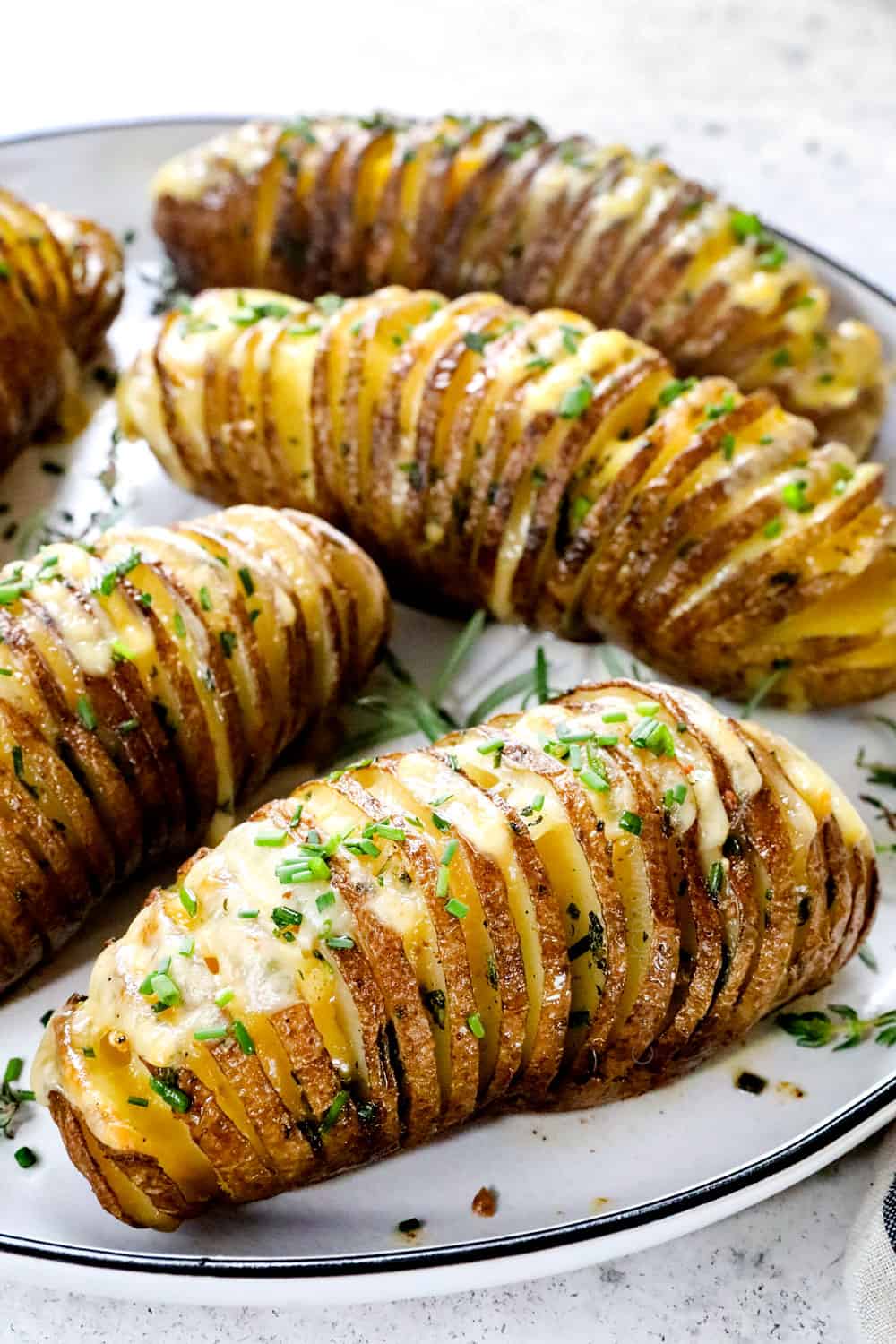 up close of Hasselback potatoes on a platter with cheese