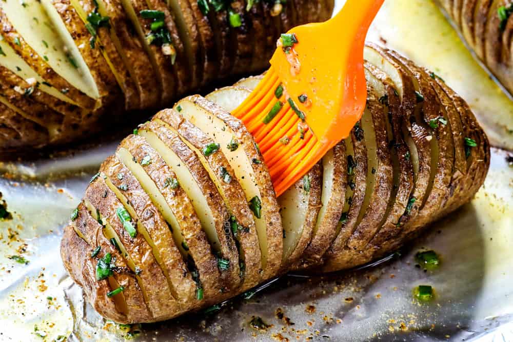 showing how to make Hasselback potatoes by brushing in between each slice with garlic thyme butter