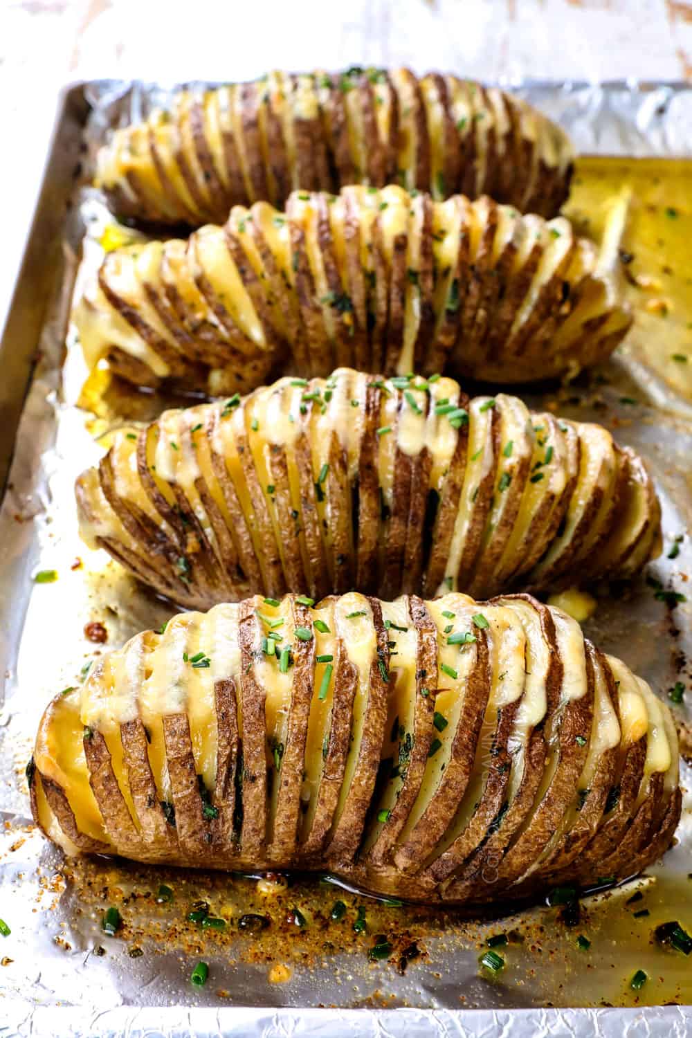 showing how to make Hasselback potato recipe by baking potatoes until the cheese is melted