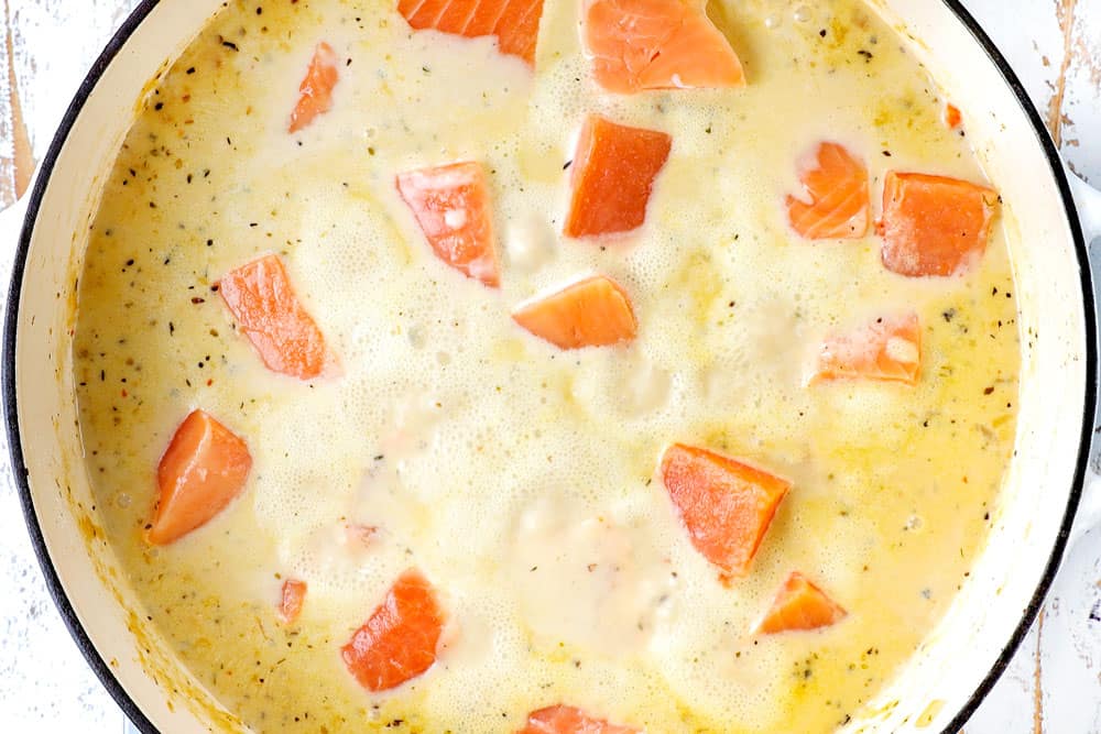 showing how to make fish chowder recipe by adding salmon the pot to simmer