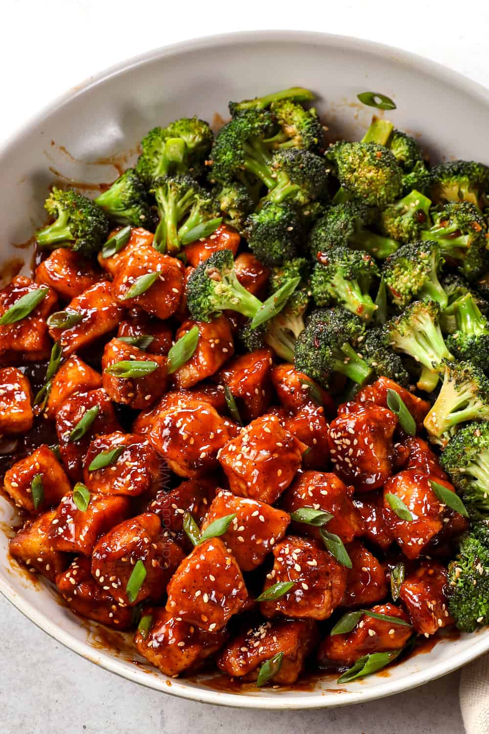 honey sesame chicken in a skillet with sesame sauce