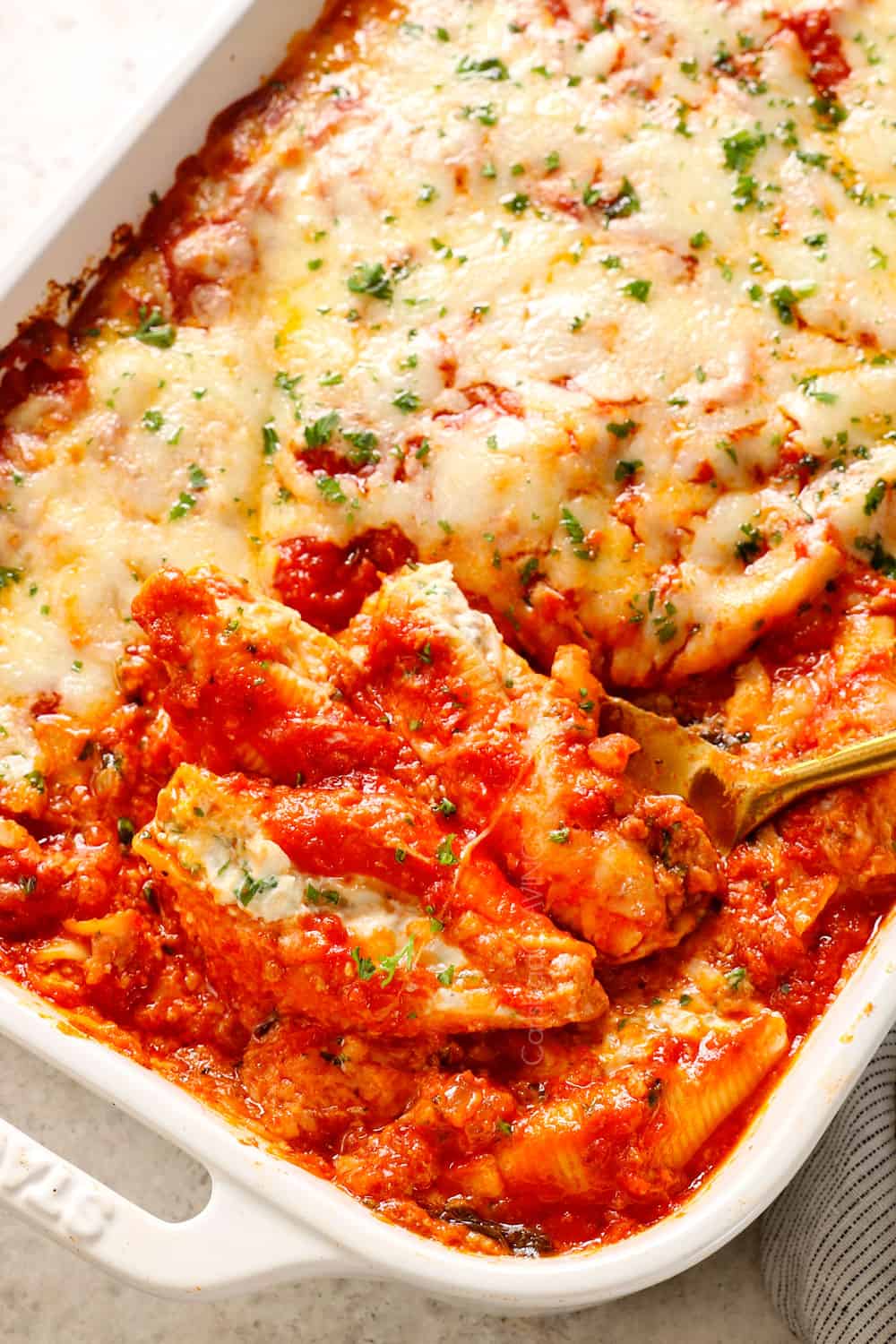 scooping up stuffed pasta shells with meat showing how meaty and cheesy it is