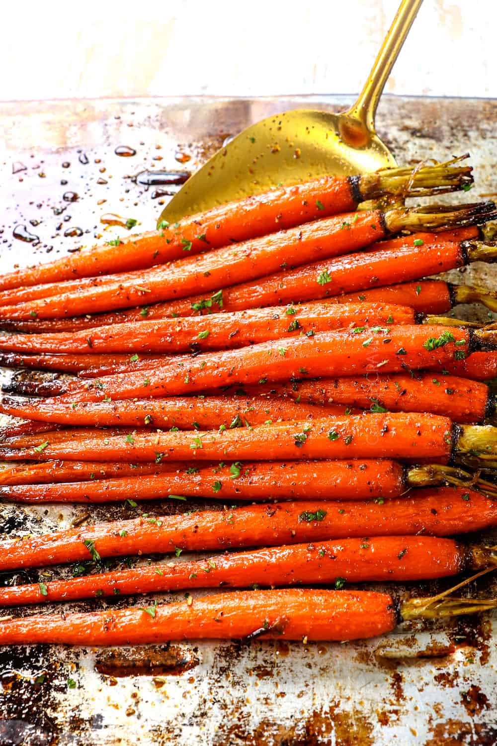 scooping up roasted carrot recipe with a spatula to serve