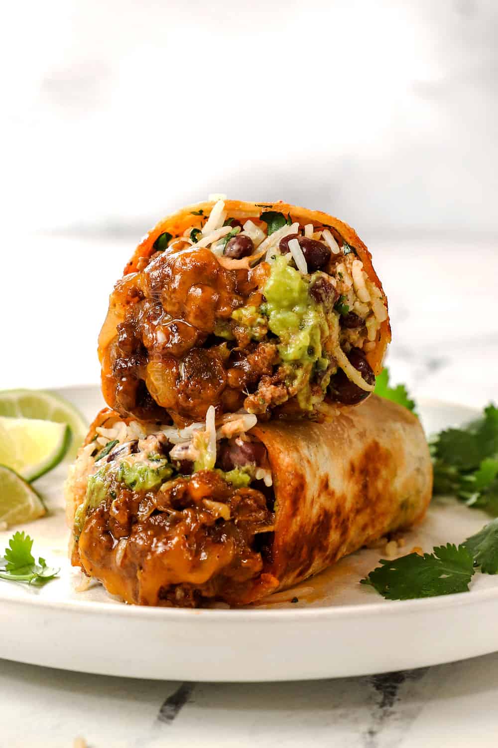 beef burritos stacked showing the cheesy ground beef filling