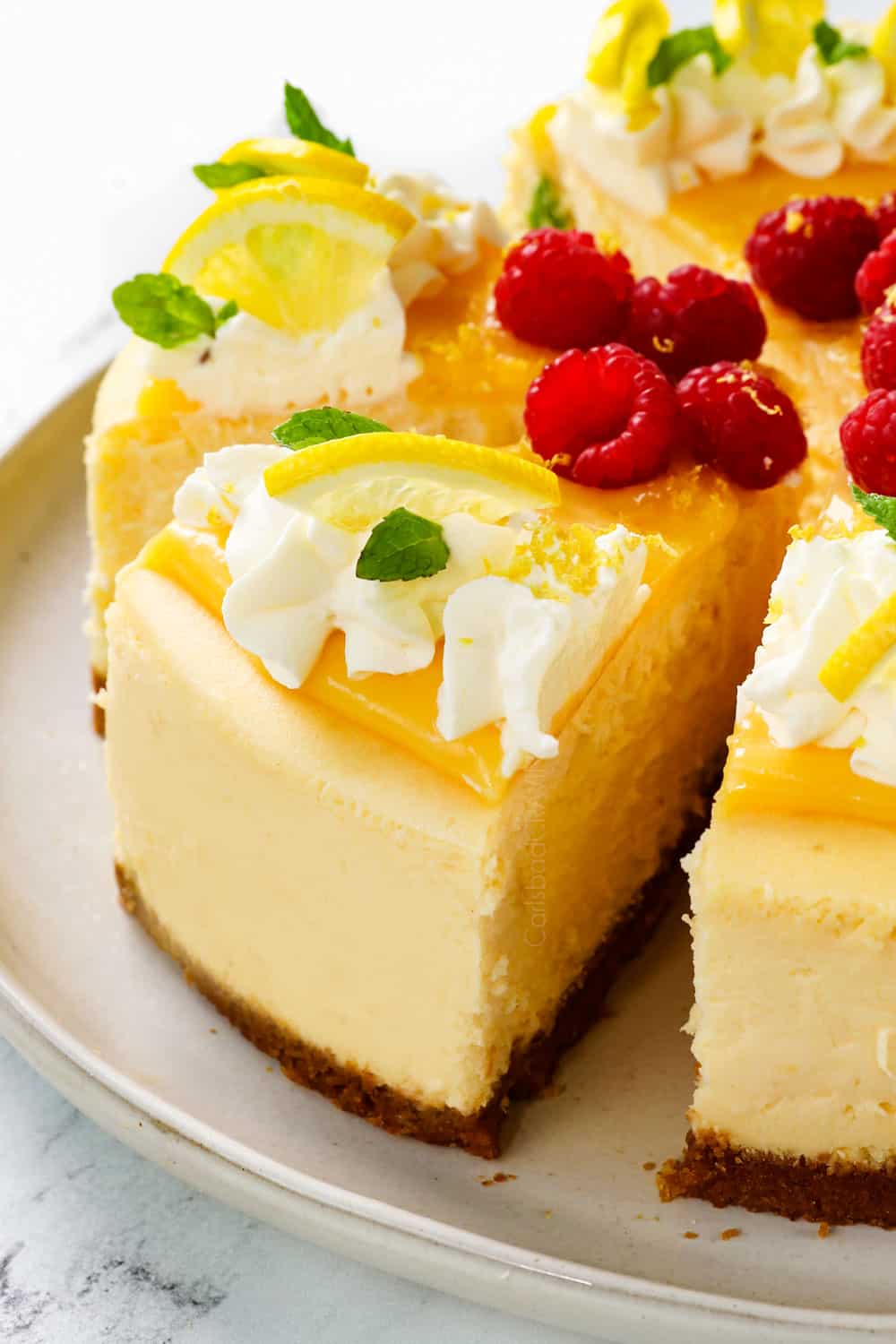 a slice of easy lemon cheesecake with lemon curd decorated with whipped cream