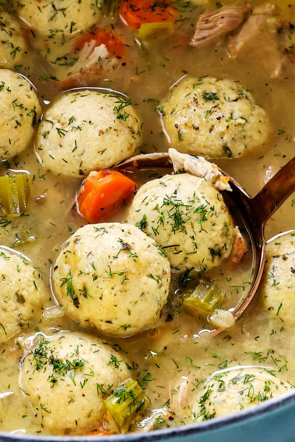 up close of a bowl of easy matzo ball soup recipe with floaters