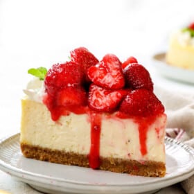 front view of a slice of strawberry cheesecake showing the glazed strawberry topping