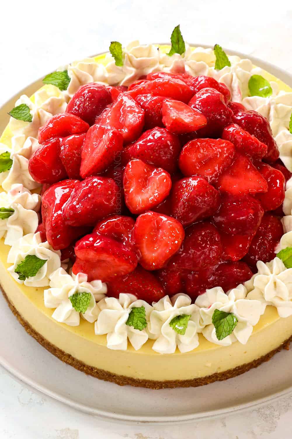 strawberry cheesecake with strawberry topping on to of the cheesecake