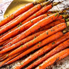 picking up oven roasted carrots with a spatula to serve
