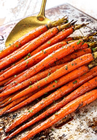 picking up oven roasted carrots with a spatula to serve