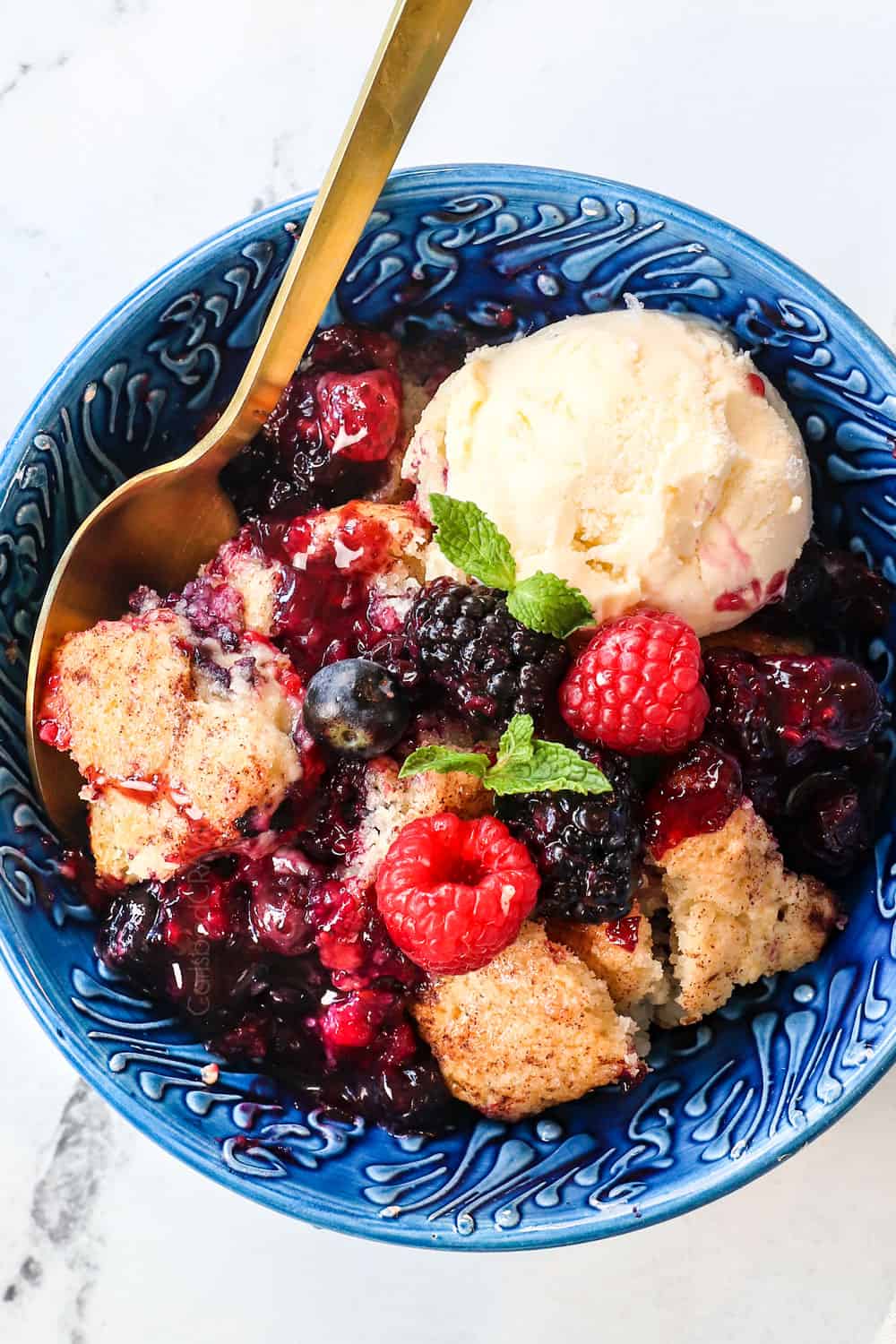 top view of a bowl of mixed berry cobbler with blackberries, blueberries, raspberries and strawberries